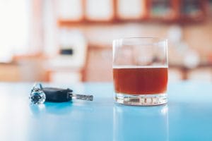 Drink driving. Car key and a glass of liquor Drink driving. Car key and a glass of liquor on table